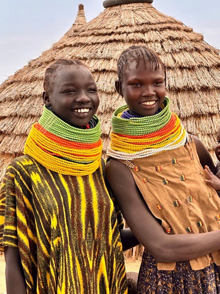 Two women in Ethiopia wearing traditional bead necklaces, expressing cultural beauty and heritage.
